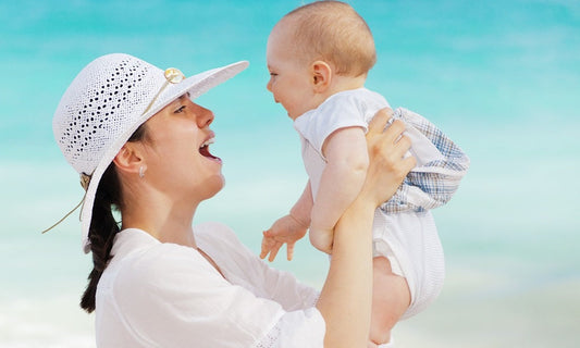 Mutter hält ihr kleines Baby im Arm und lacht