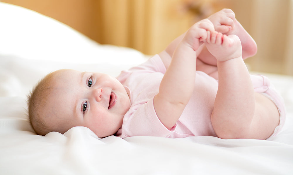 kleines Baby liegt auf einem Bett