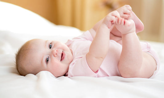 kleines Baby liegt auf einem Bett