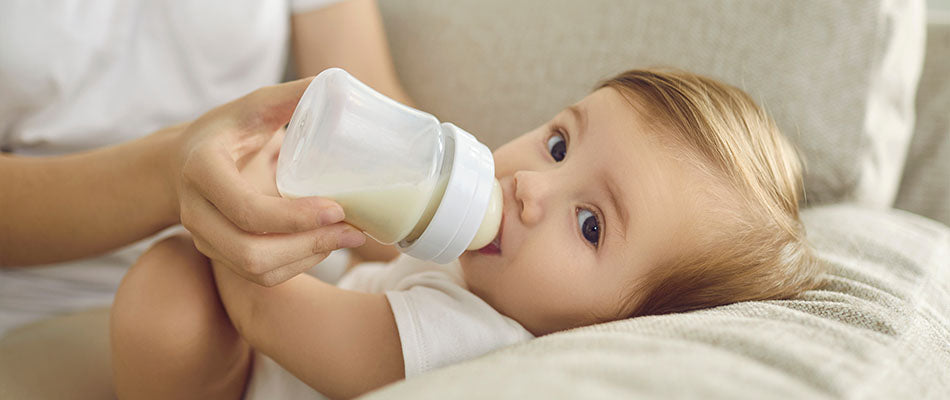 Ein Baby trinkt Milch aus der Flasche.